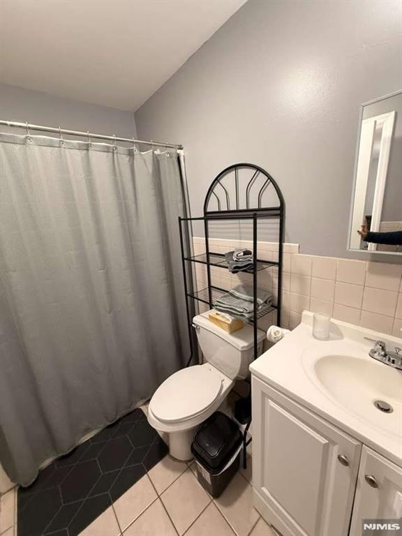 168 Grove Street Passaic, NJ 07055 - Photo 5 of 12 a bathroom with a toilet a sink and a window