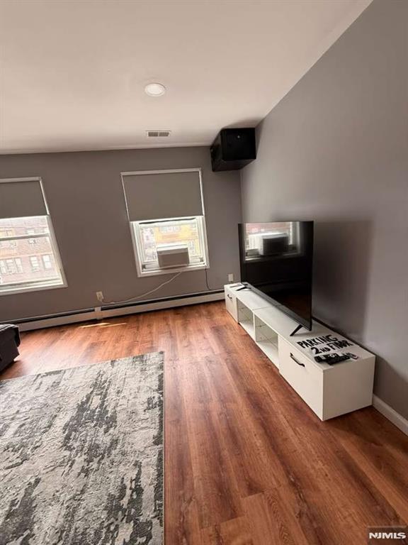 168 Grove Street Passaic, NJ 07055 - Photo 8 of 12 a living room with hardwood floor furniture and a flat screen tv