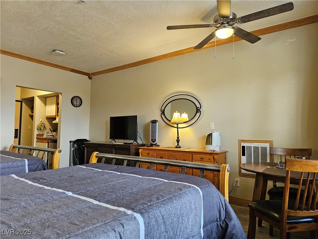 223 Hunter Ridge Drive, Unit 121 Brian Head, UT 84719 - Photo 14 of 35 Bedroom with dark wood-type flooring, ornamental molding, a textured ceiling, and a ceiling fan