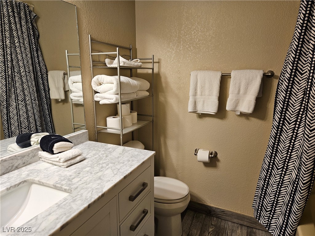 223 Hunter Ridge Drive, Unit 121 Brian Head, UT 84719 - Photo 7 of 35 Bathroom with wood finished floors, vanity, a textured wall, and curtained shower