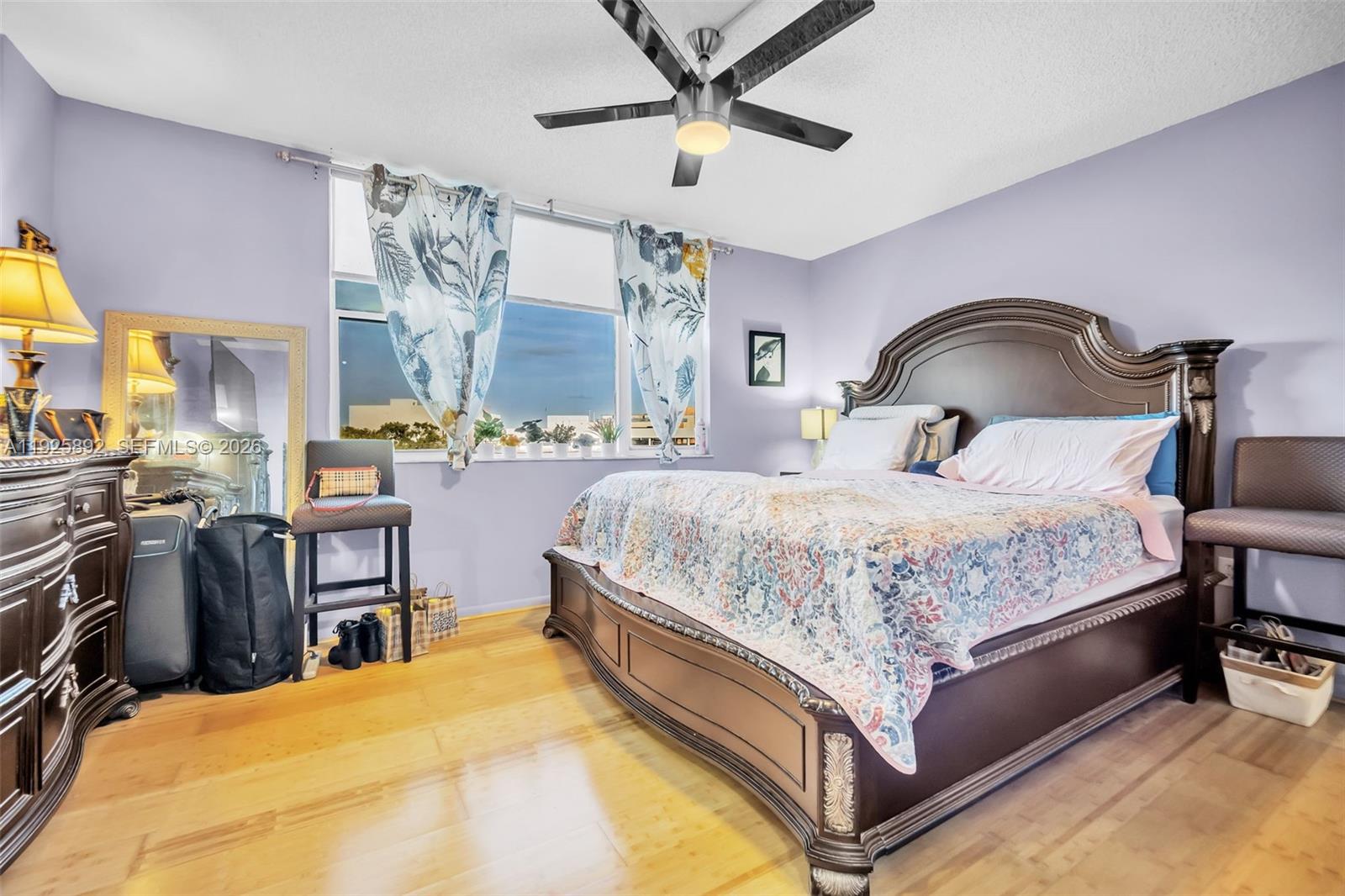 3850 Washington Street, Unit 409 Hollywood, FL 33021 - Photo 13 of 18 a bedroom with a bed and dresser with the potted plants