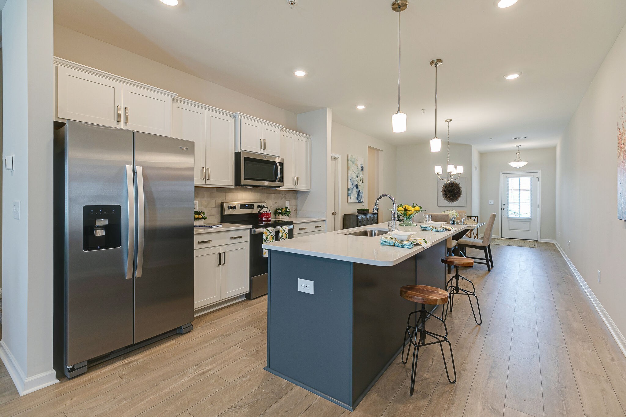 1087 June Wilde Ridge Spring Hill, TN 37174 - Photo 8 of 19 a kitchen with kitchen island a refrigerator a stove a sink and a microwave
