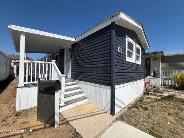 a front view of a house with stairs and wooden fence