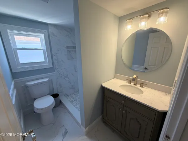 a bathroom with a toilet sink and mirror
