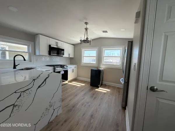 a kitchen with granite countertop a stove a sink and a refrigerator
