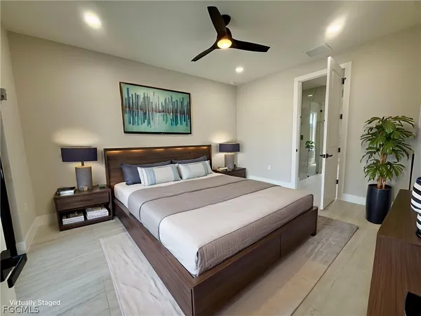 a bedroom with a large bed and a chandelier