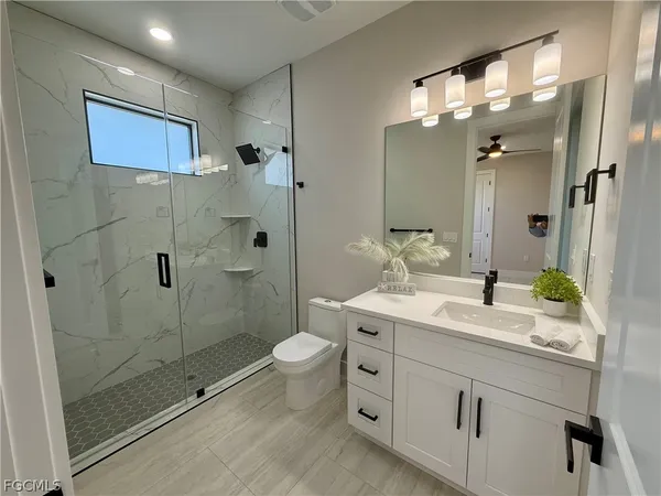 a bathroom with a double vanity sink mirror and shower