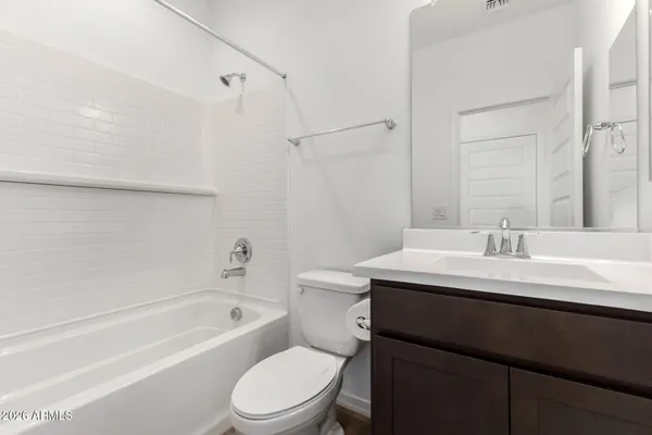 a bathroom with a sink a toilet a mirror and shower