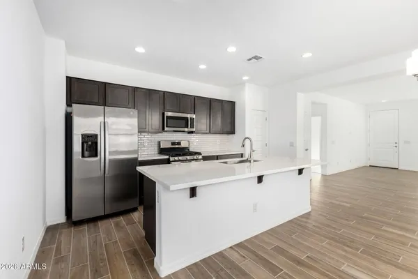 a kitchen with stainless steel appliances a sink stove and refrigerator