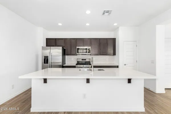 a kitchen with stainless steel appliances a refrigerator sink and microwave