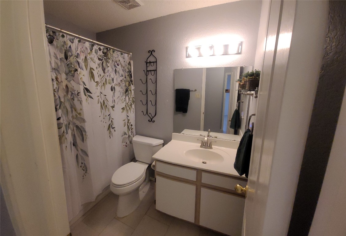 1805 Timber Ridge Drive Cedar Park, TX 78613 - Photo 13 of 25 a bathroom with a sink a toilet a mirror and shower curtain
