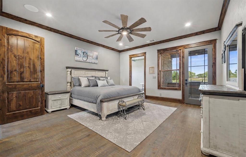 10641 County Road 632 Blue Ridge, TX 75424 - Photo 12 of 34 a bedroom with a large bed a chandelier and windows