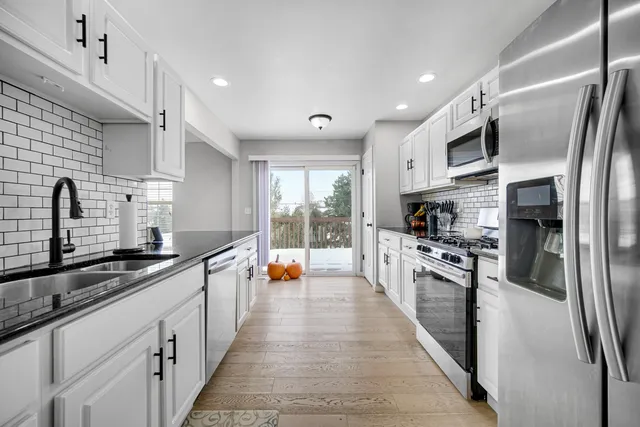 a large kitchen with stainless steel appliances lots of counter space and a sink