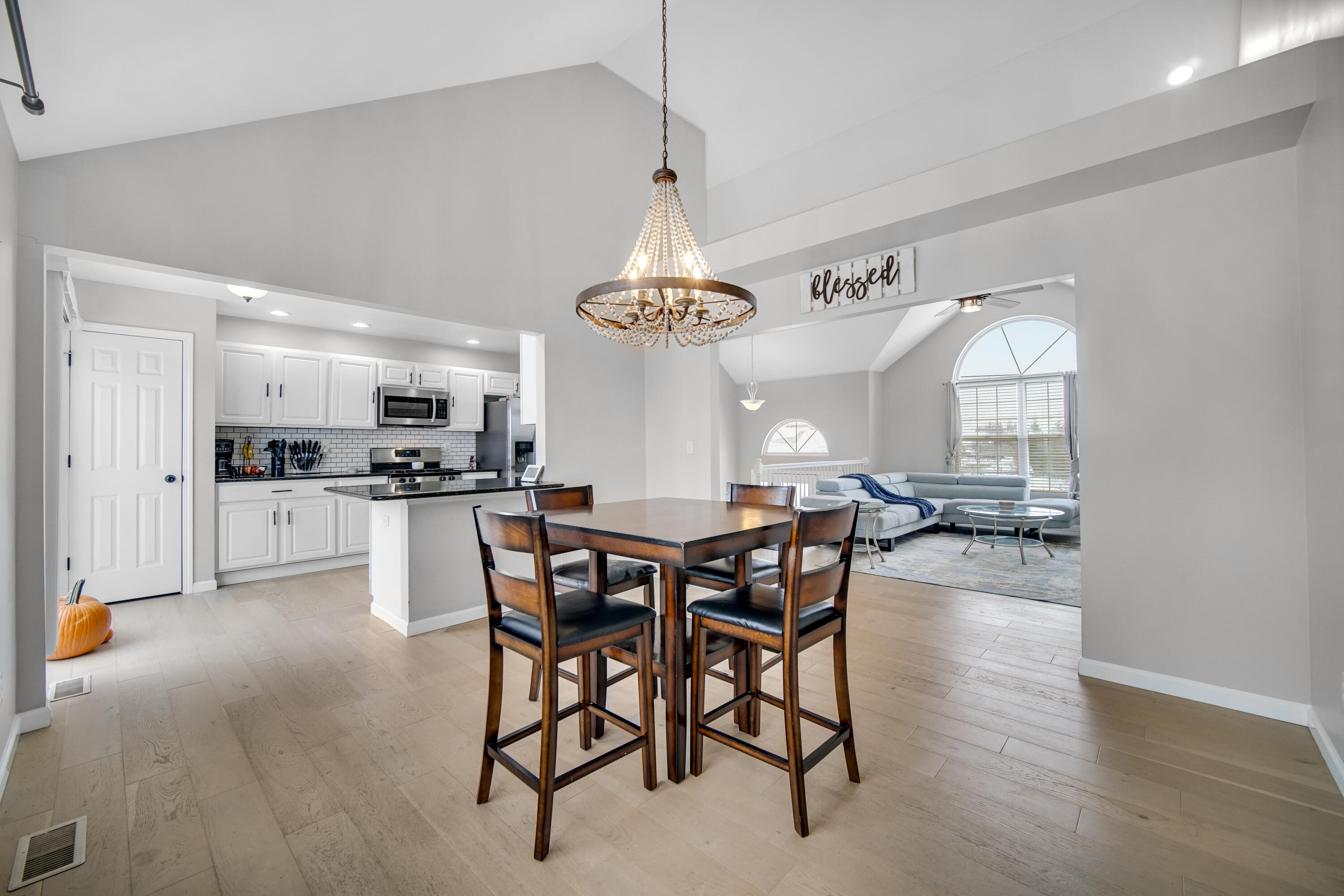 10487 Pinnacle Street Crown Point, IN 46307 - Photo 7 of 27 a view of a dining room and livingroom with furniture wooden floor a chandelier