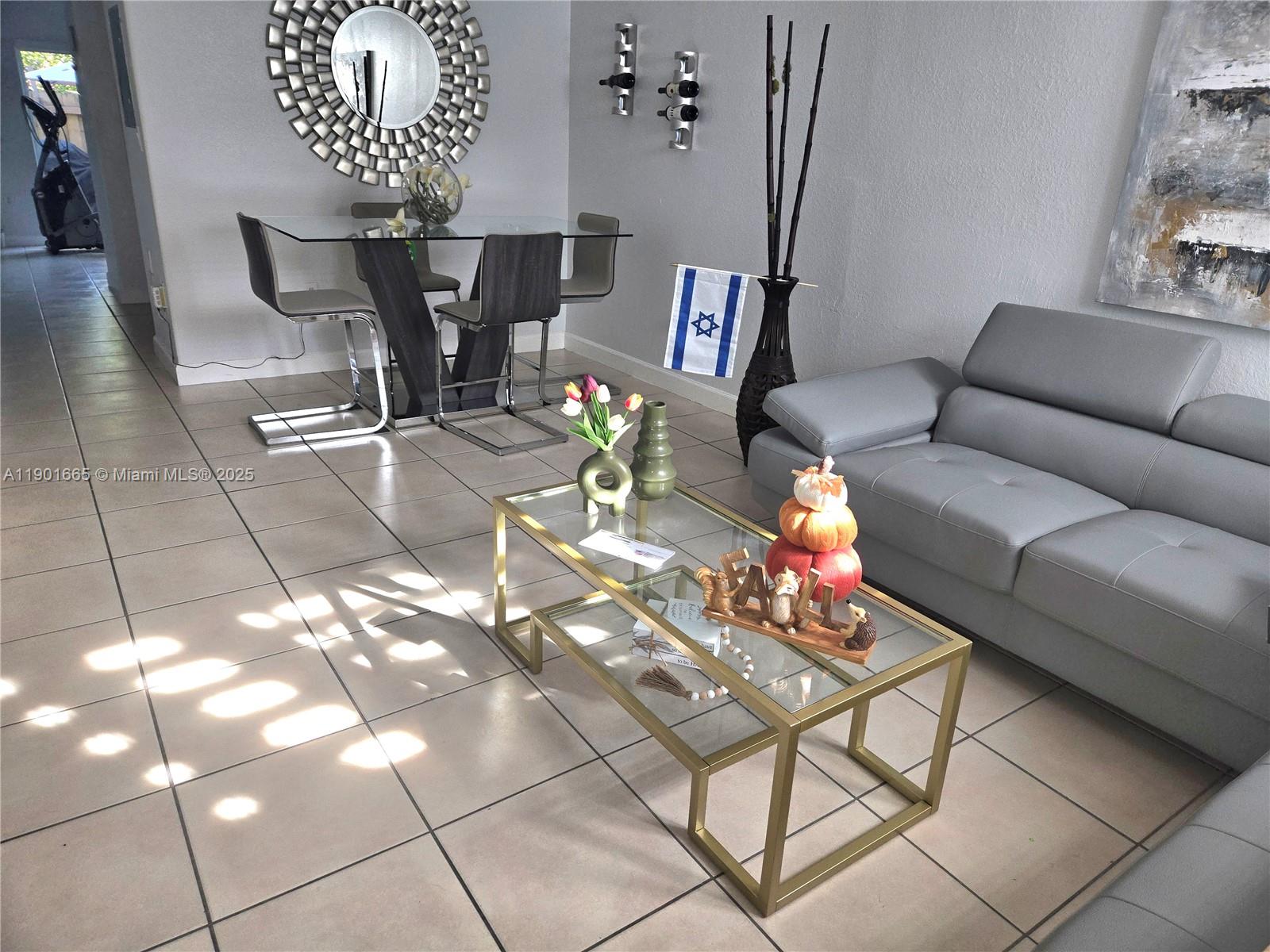 2731 Southeast 17th Avenue, Unit 100 Homestead, FL 33035 - Photo 2 of 12 a living room with furniture and a chandelier