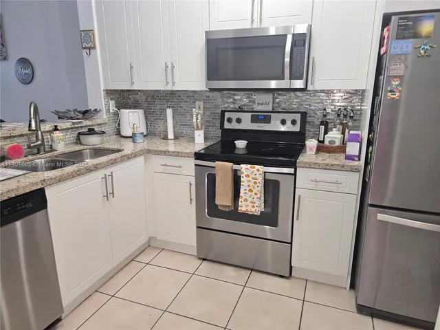 a kitchen with stainless steel appliances granite countertop a stove microwave and refrigerator