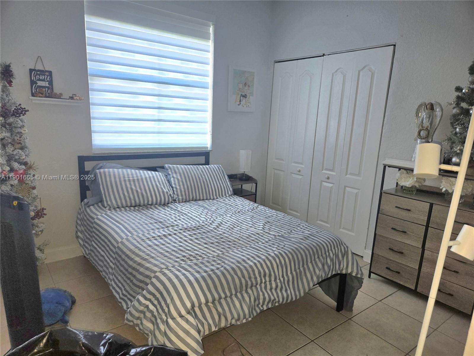 2731 Southeast 17th Avenue, Unit 100 Homestead, FL 33035 - Photo 8 of 12 a bedroom with a bed and a window