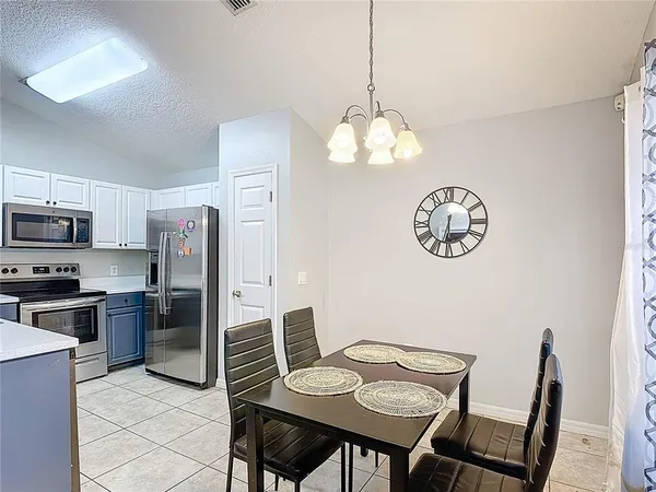a view of a dining room with furniture a chandelier and wooden floor