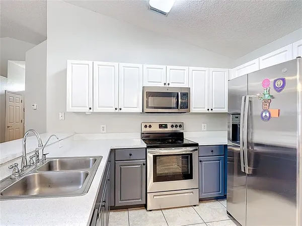 a kitchen with white cabinets a sink and appliances