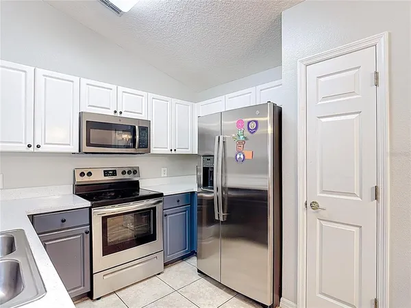 a kitchen with stainless steel appliances granite countertop a refrigerator and a stove top oven