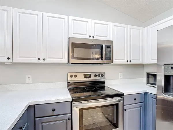 a kitchen with granite countertop white cabinets and stainless steel appliances