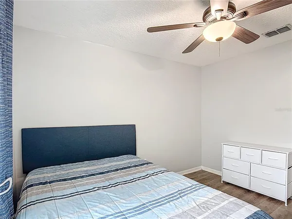 a bedroom with a bed and a ceiling fan