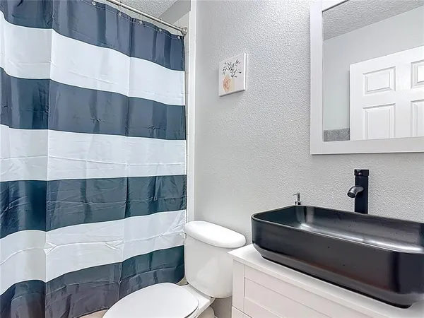 a bathroom with a sink a toilet and mirror