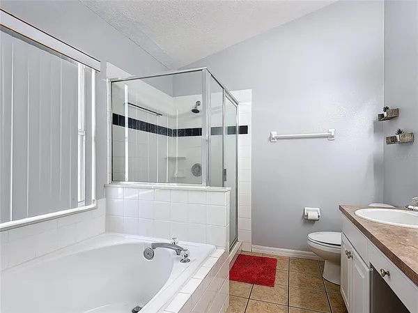 a bathroom with a tub shower sink and toilet
