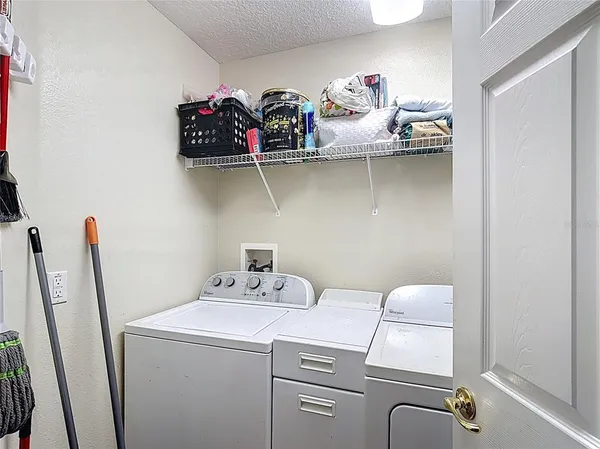 a utility room with dryer washer and shoe rack