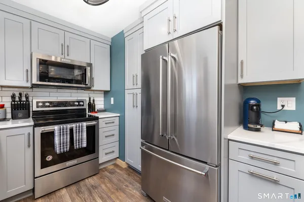 a kitchen with stainless steel appliances a refrigerator stove and microwave