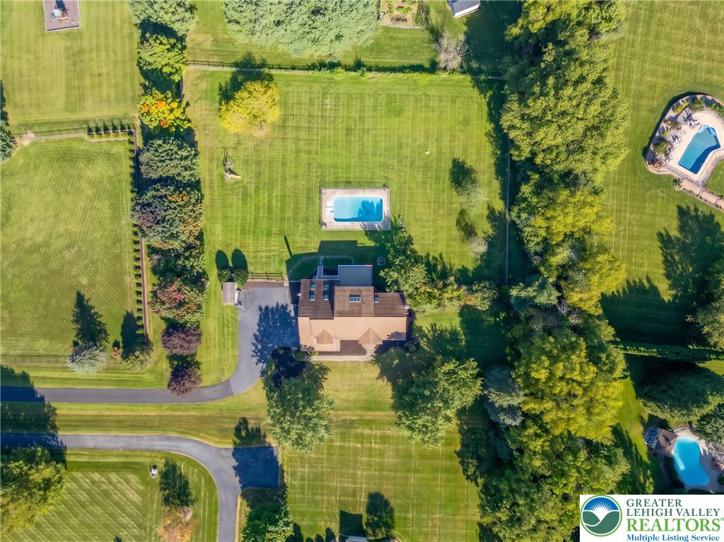 630 Clearfield Road Nazareth, PA 18064 - Photo 9 of 100 An aerial view showcases a spacious green lawn surrounding the home and private swimming pool.