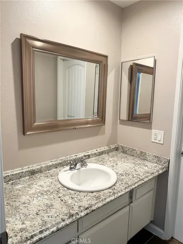 a bathroom with a granite countertop sink and a mirror