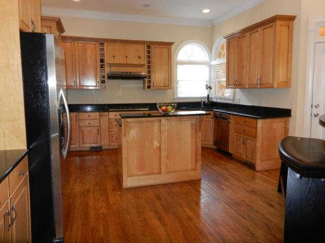 a kitchen with stainless steel appliances granite countertop a sink refrigerator and microwave