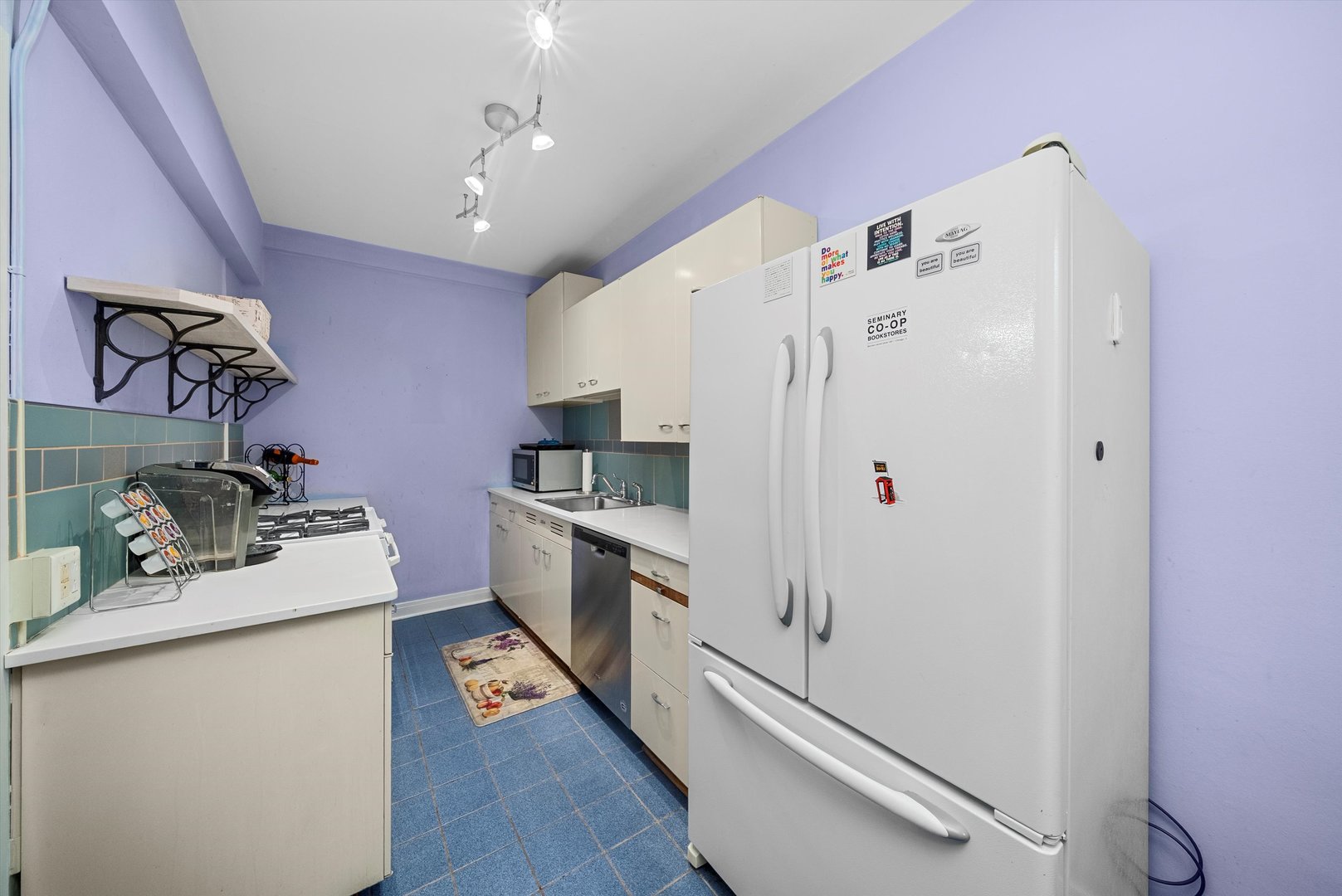 1157 East 56th Street, Unit 3 Chicago, IL 60637 - Photo 7 of 14 a kitchen with granite countertop a refrigerator a sink dishwasher and a stove with white countertops