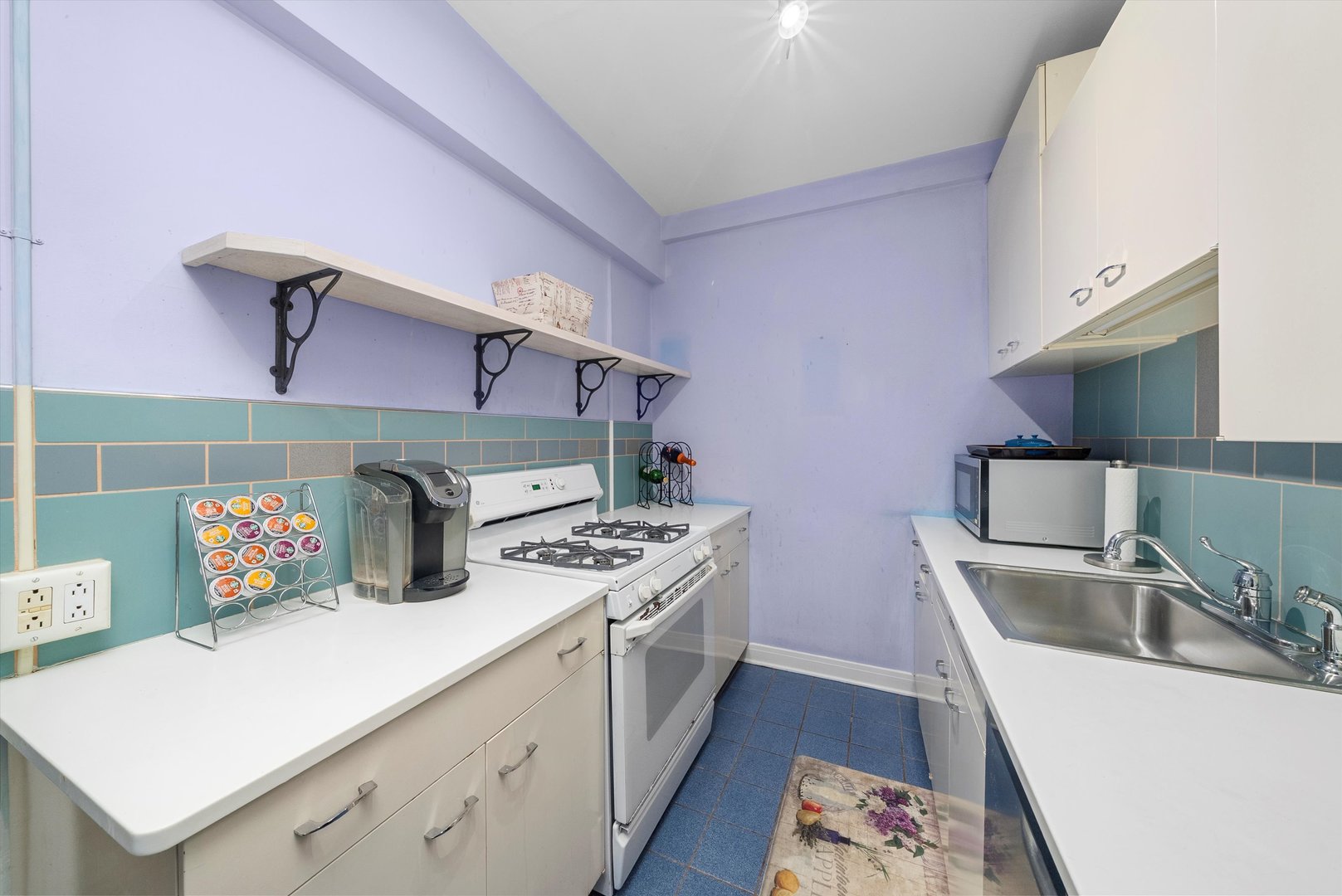 1157 East 56th Street, Unit 3 Chicago, IL 60637 - Photo 8 of 14 a kitchen with sink a stove and cabinets