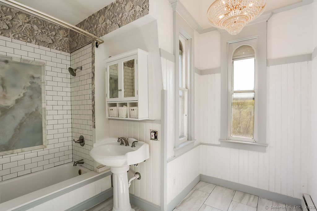 220 Walnut Street Winchester, CT 06098 - Photo 16 of 20 a bathroom with a sink a mirror and a bathtub