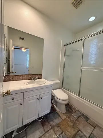 a living room with two couches and a dining table with wooden floor