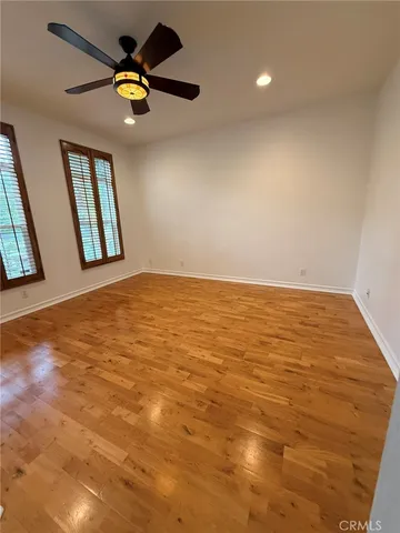an empty room with a window and a ceiling fan