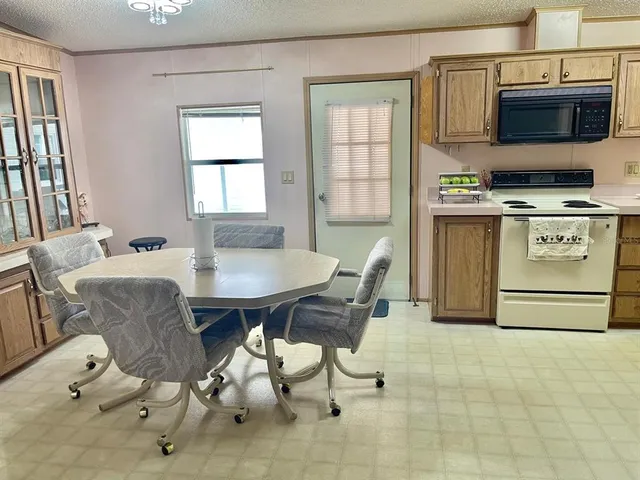 a view of kitchen with stainless steel appliances dining table and chairs
