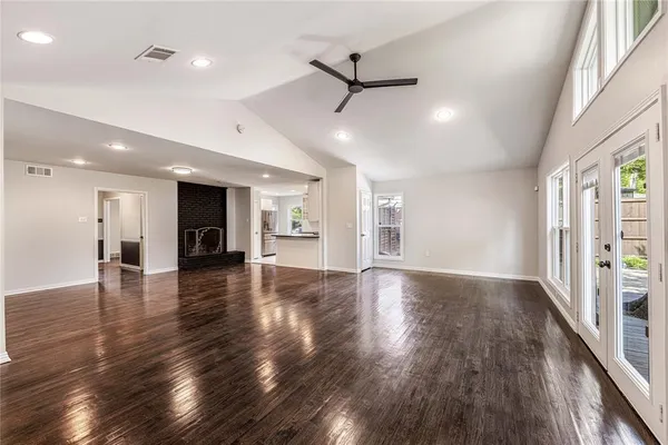 a view of empty room with wooden floor and windows