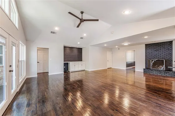 a view of empty room with wooden floor and fireplace
