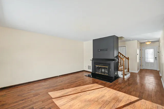 a living room with wooden floors and a fireplace