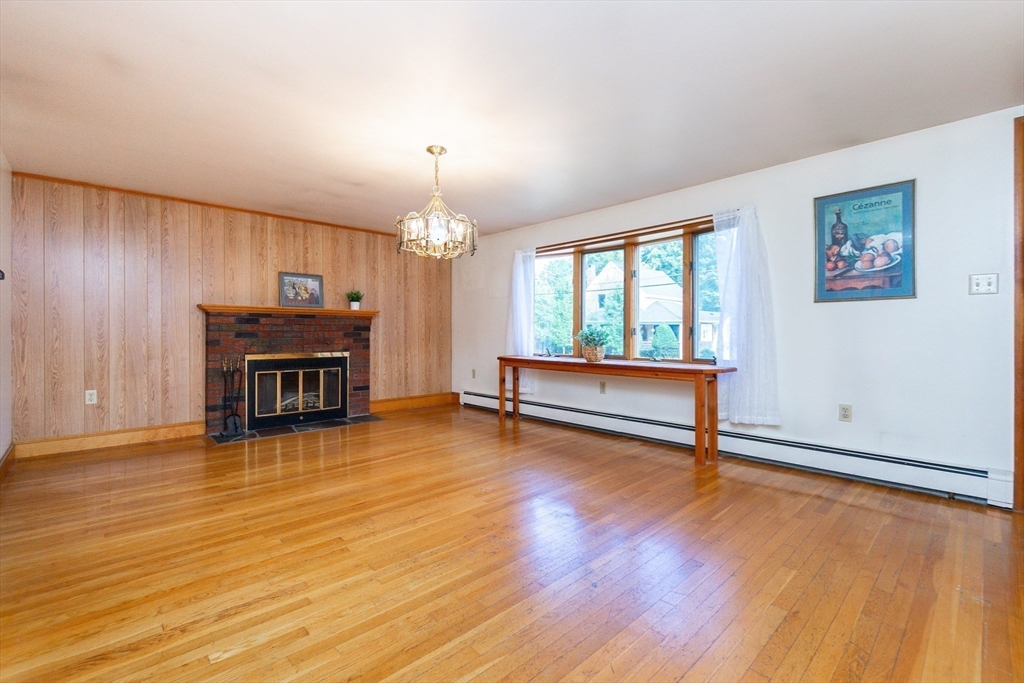 66 Depot Street Easton, MA 02375 - Photo 4 of 40 an empty room with fireplace wooden floor and windows