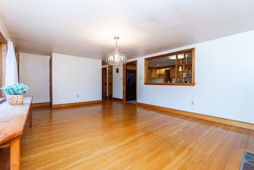 66 Depot Street Easton, MA 02375 - Photo 6 of 40 an empty room with wooden floor and chandelier
