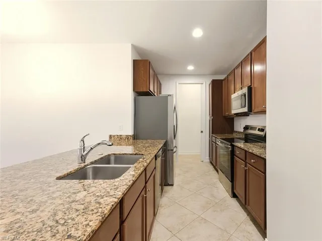 a view of kitchen with granite countertop cabinets and oven