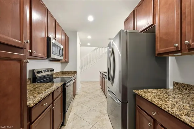 a kitchen with granite countertop cabinets stainless steel appliances and a counter space