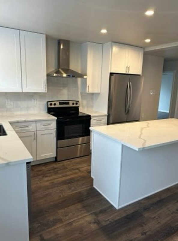 4520 Speedway, Unit A Austin, TX 78751 - Photo 3 of 18 Rich wood-textured flooring contrasts beautifully with crisp cabinetry and a central stone-topped island.