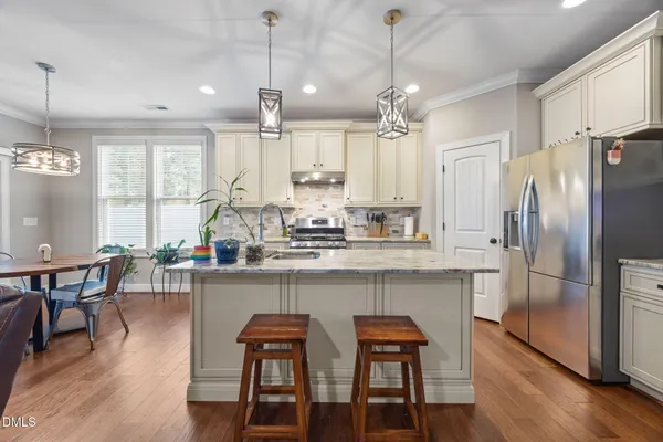 a kitchen with a table chairs refrigerator and microwave
