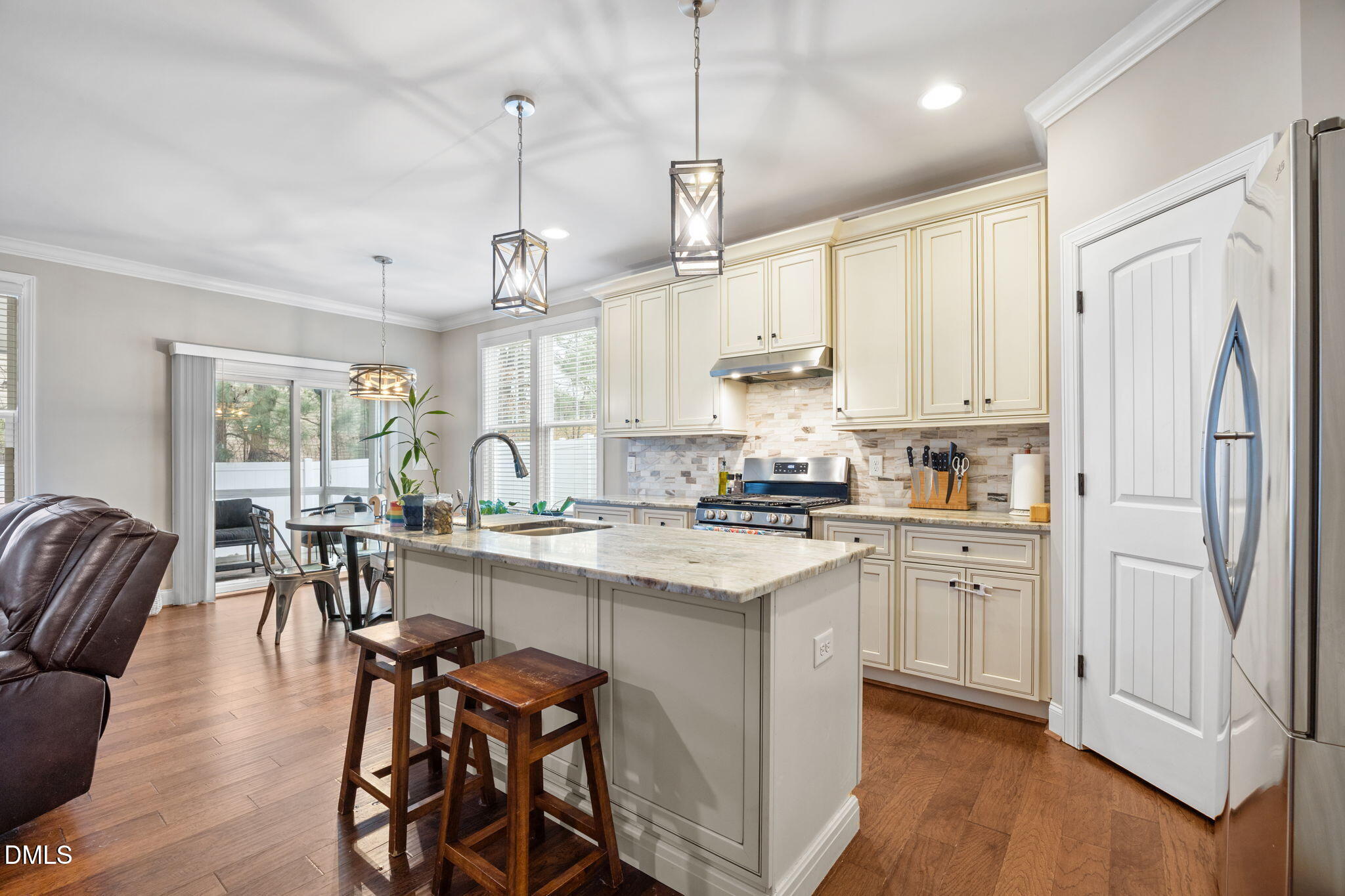3724 Massey Ridge Court Raleigh, NC 27616 - Photo 3 of 30 a kitchen with stainless steel appliances granite countertop a stove top oven a refrigerator a sink and white cabinets with wooden floor