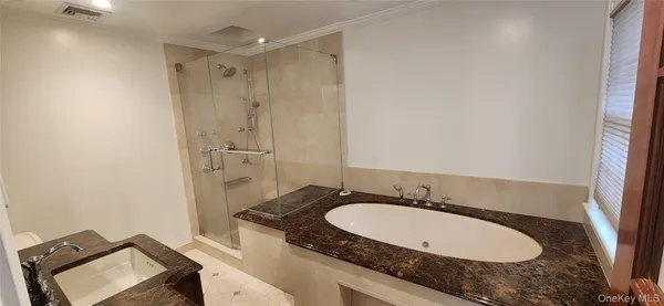 a bathroom with a granite countertop sink a mirror and a bathtub